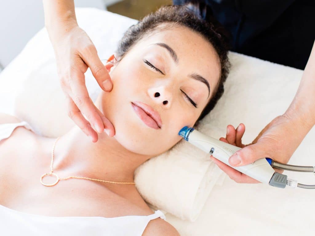 Professional aesthetician performing HydraFacial treatment on client at Infini Cosmetic in Scottsdale